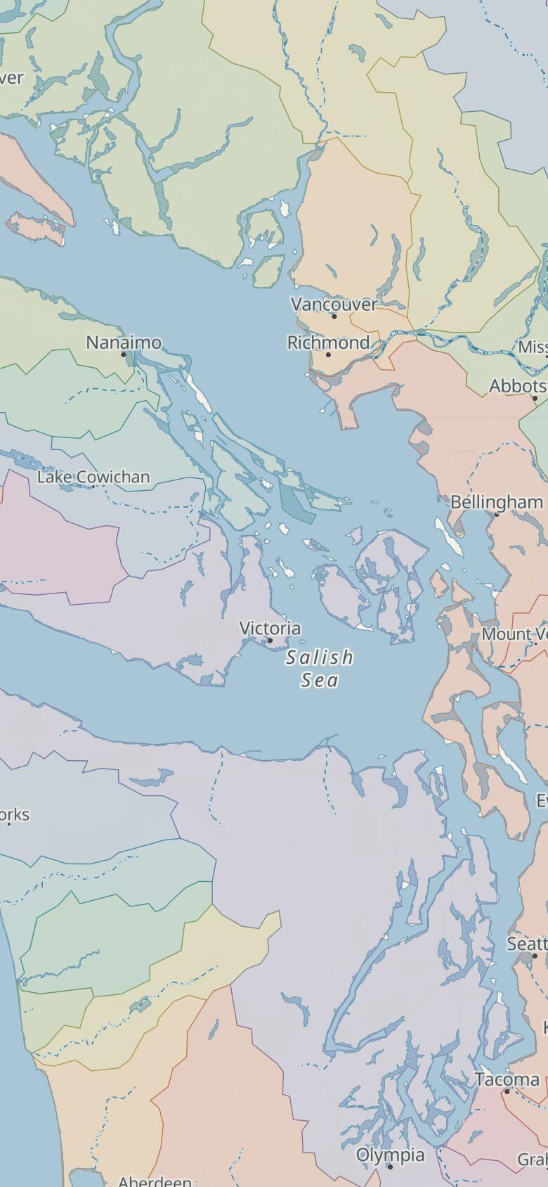 The Salish Sea and its drainage basins: Vancouver Island and the Olympic Peninsula around the Strait of Georgia, the Strait of Juan de Fuca and Puget Sound, each watershed a different colour, with Victoria near the centre.